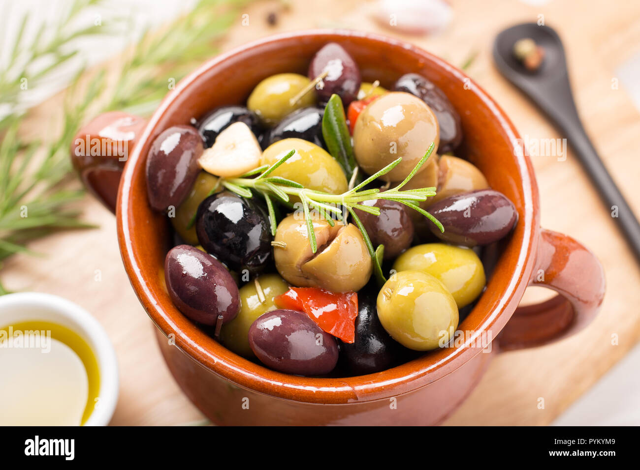 Olive marinate con aglio, rosmarino, olio d'oliva e spezie. Stile rustico Foto Stock