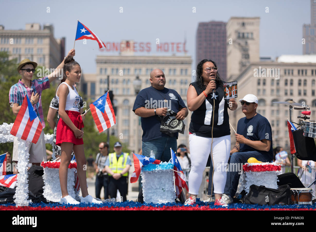 Chicago, Illinois, Stati Uniti d'America - 16 Giugno 2018: Il Puerto Rican Day Parade, donna canta il Puerto Rican inno nazionale all'inizio della sfilata mentre hol Foto Stock