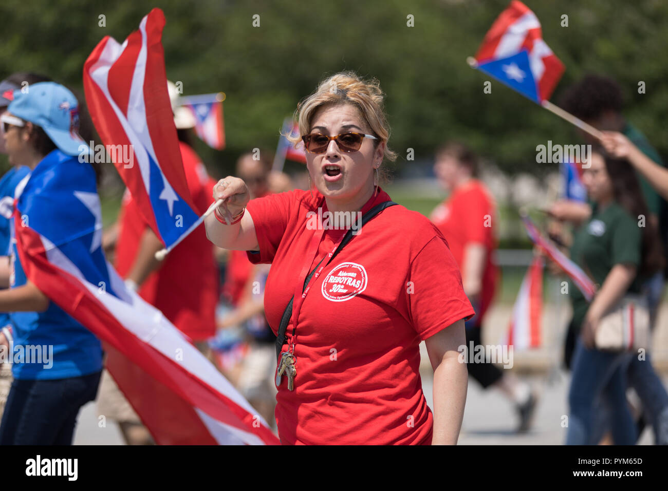 Chicago, Illinois, Stati Uniti d'America - 16 Giugno 2018: Il Puerto Rican Day Parade, Donna sventolando il Puerto Rican bandiera percorrendo la strada durante la sfilata Foto Stock