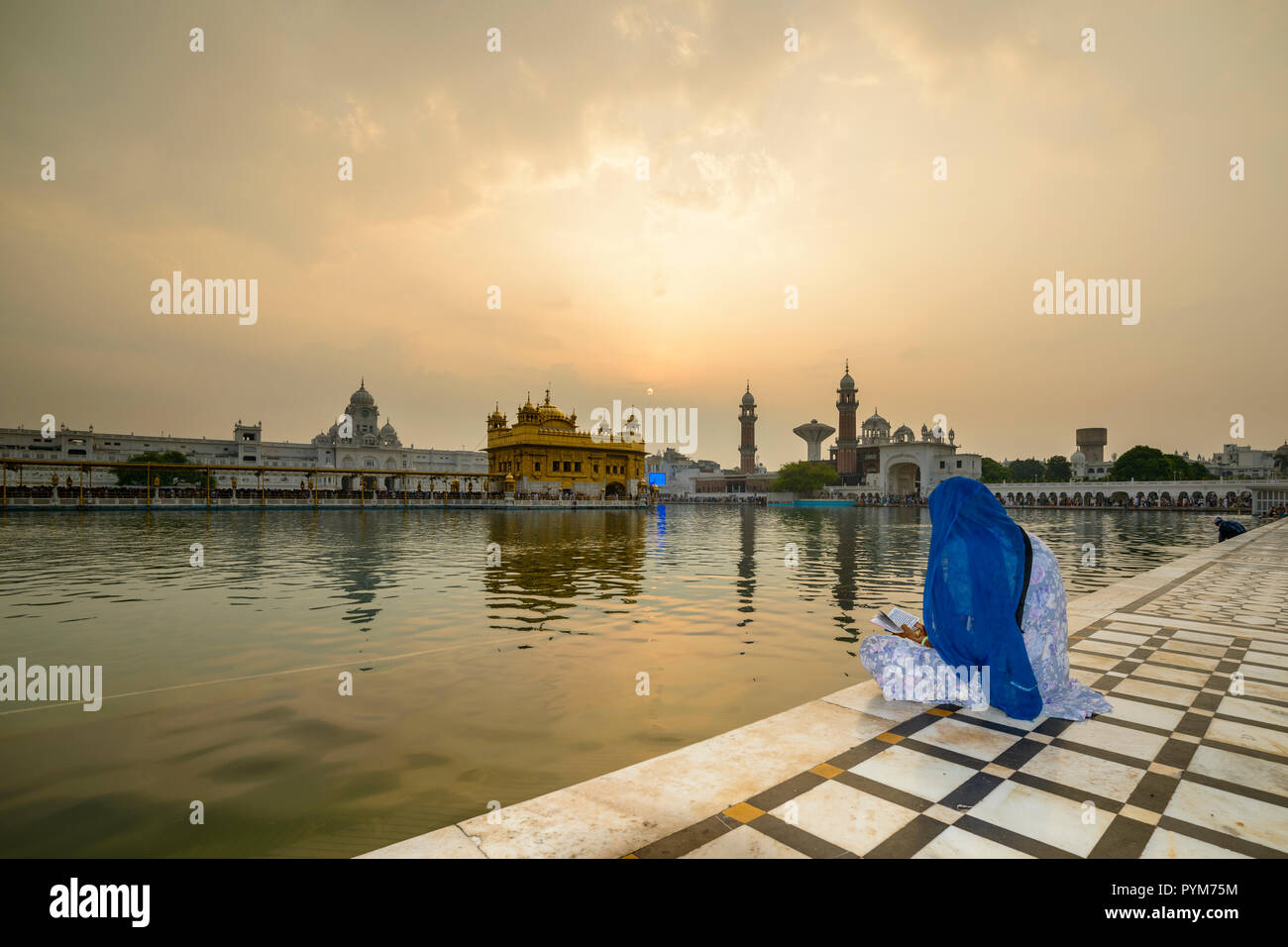 Un devoto sikh è seduta e la meditazione del santo piscina dell'Harmandir Sahib, il Tempio Dorato Foto Stock Un devoto sikh è seduta e la meditazione del santo piscina dell'Harmandir Sahib, il Tempio Dorato Foto Stock