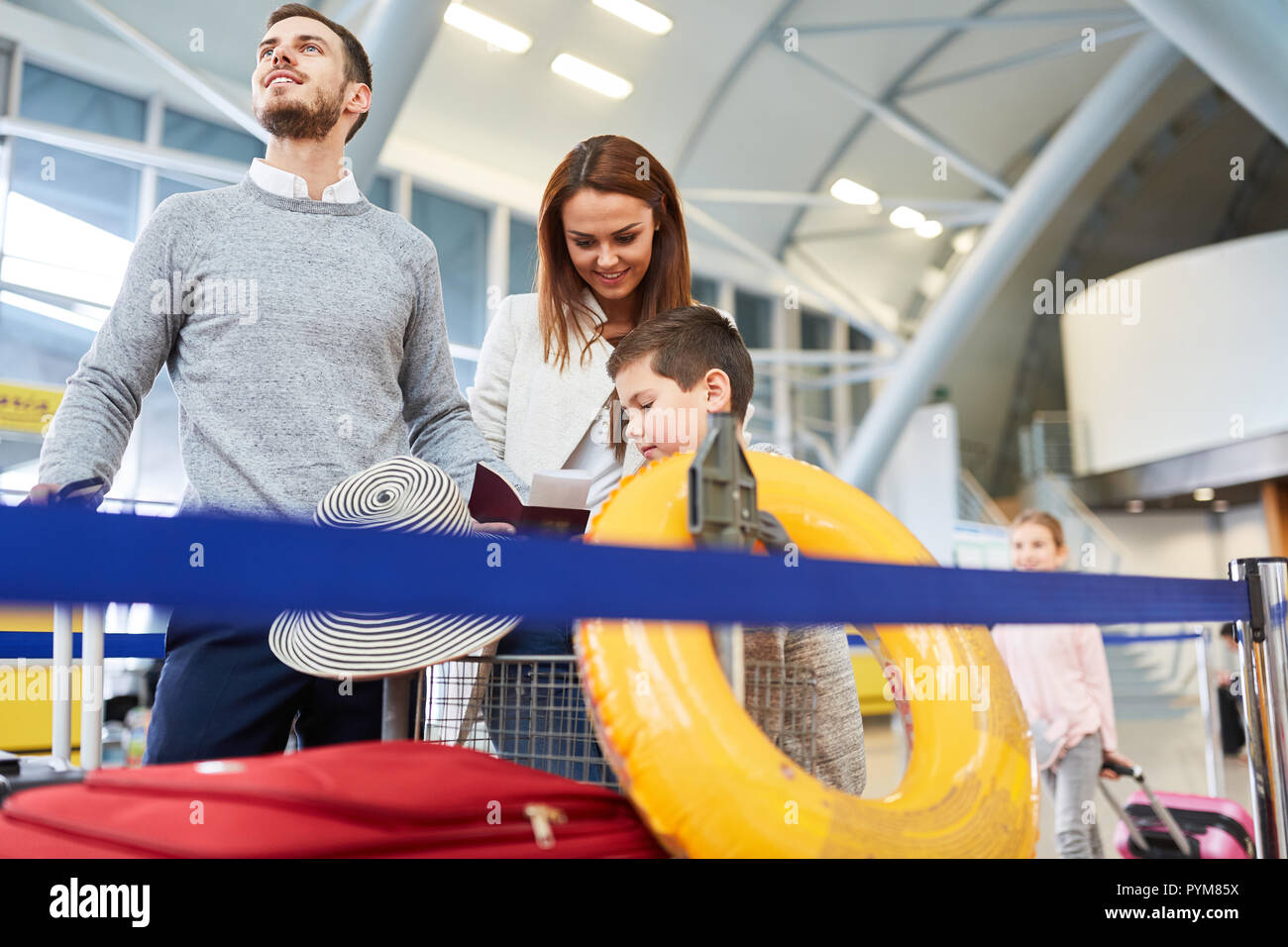 Famiglia e due bambini con bagagli volare in vacanze estive e attendere per il volo Foto Stock