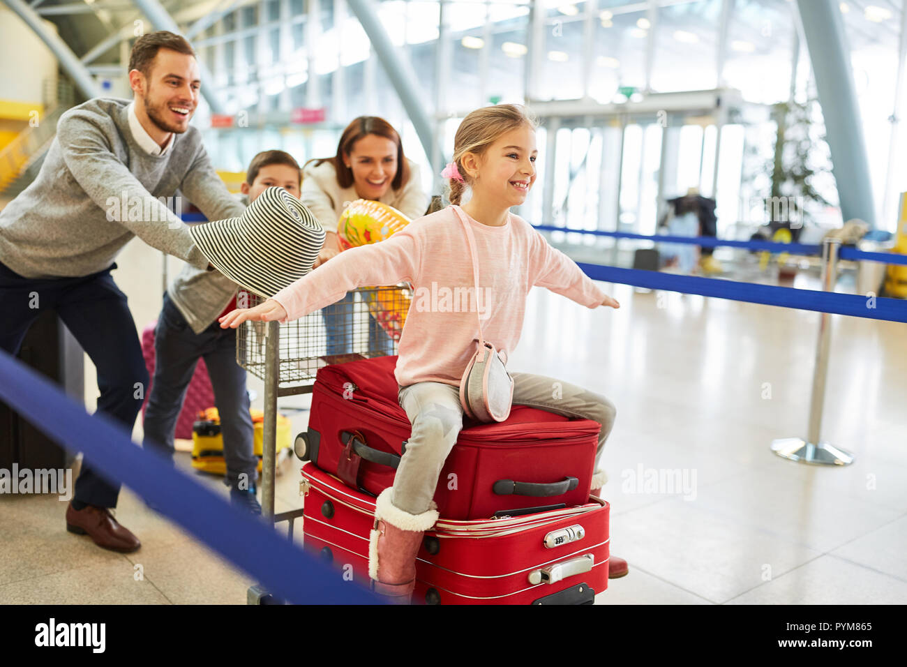 La famiglia felice e i bambini sulla strada per vacanza con la famiglia in terminal aeroporto Foto Stock