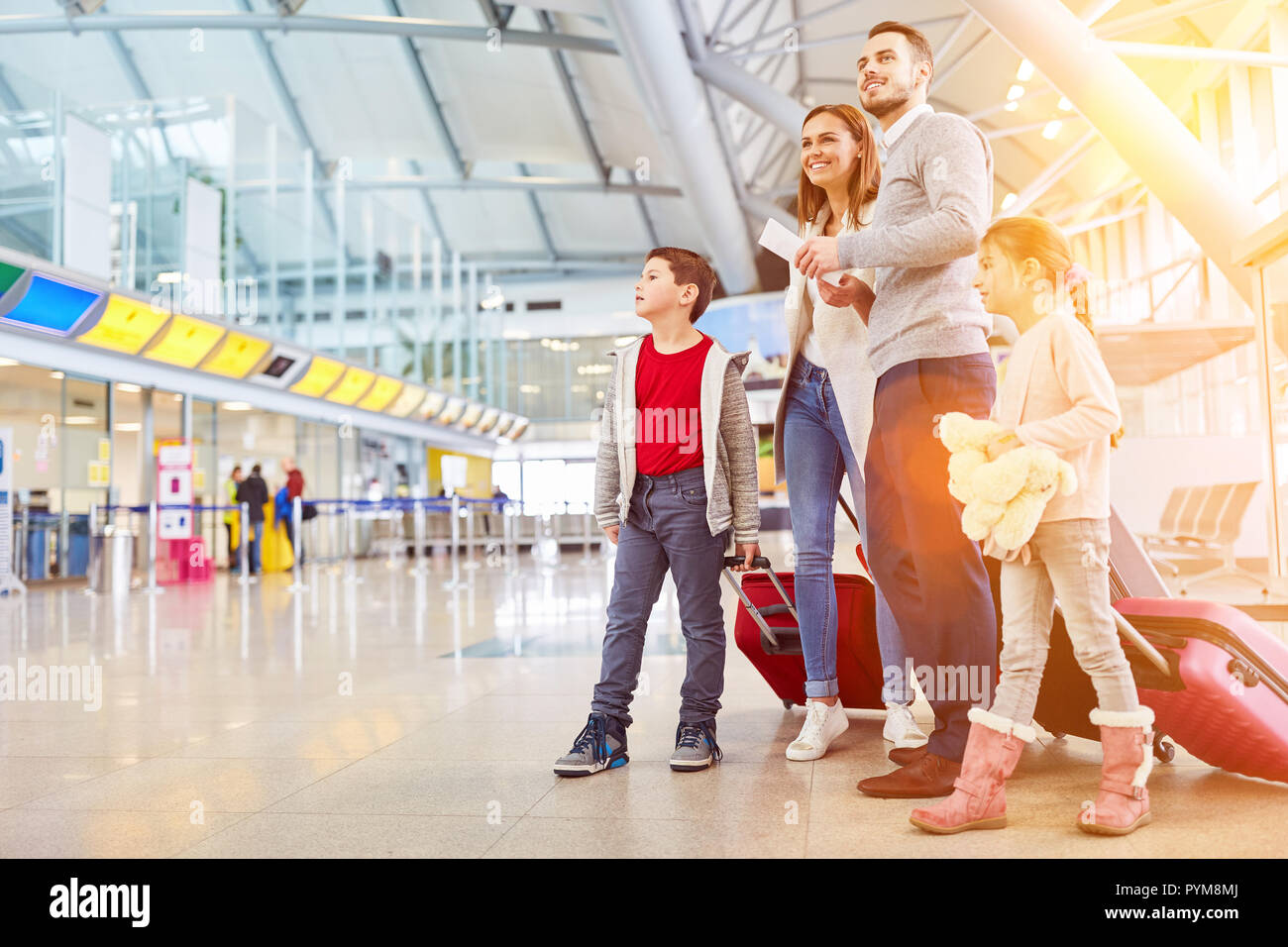 Famiglia con due bambini in vacanza in aeroporto o stazione ferroviaria Foto Stock