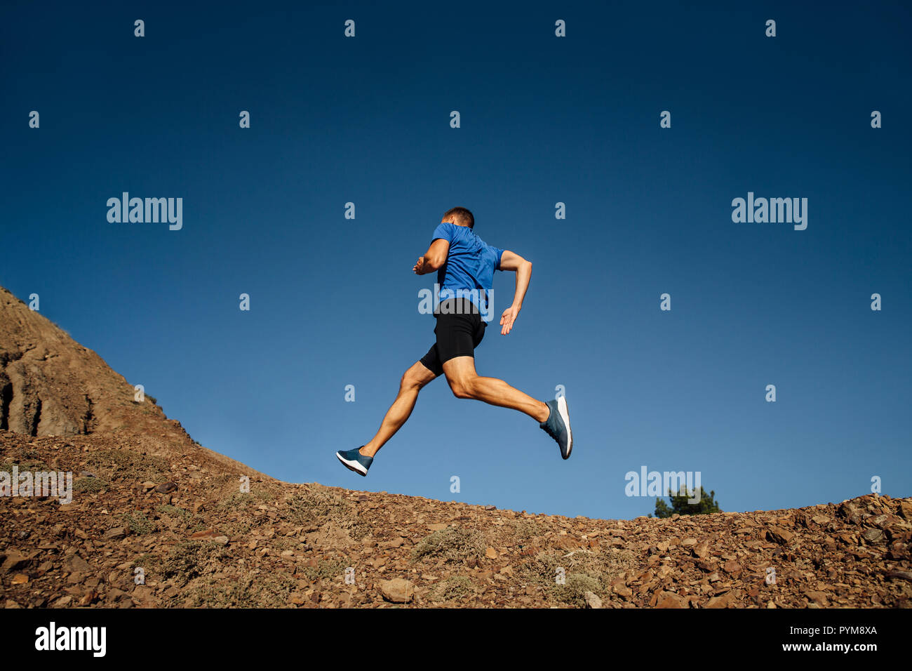 Atleta runner acceso in salita il sentiero di montagna Foto Stock