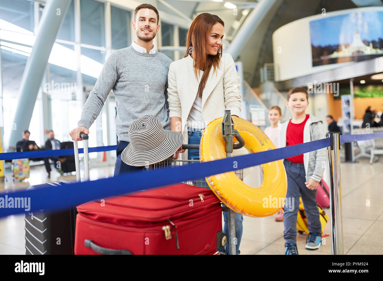 Famiglia con due bambini e bagagli in airport terminal vola durante le vacanze estive Foto Stock