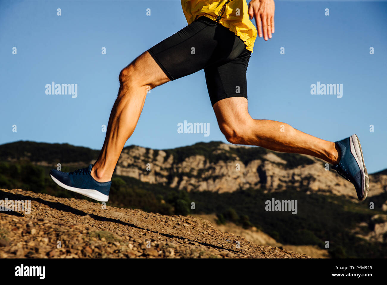 Gambe runner maschio in esecuzione sullo sfondo di montagne e di sky Foto Stock