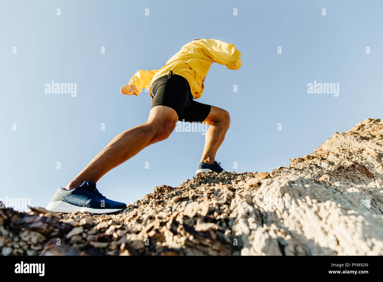 Atleta maschio si inerpica su per una ripida montagna. concetto di superare le difficoltà Foto Stock