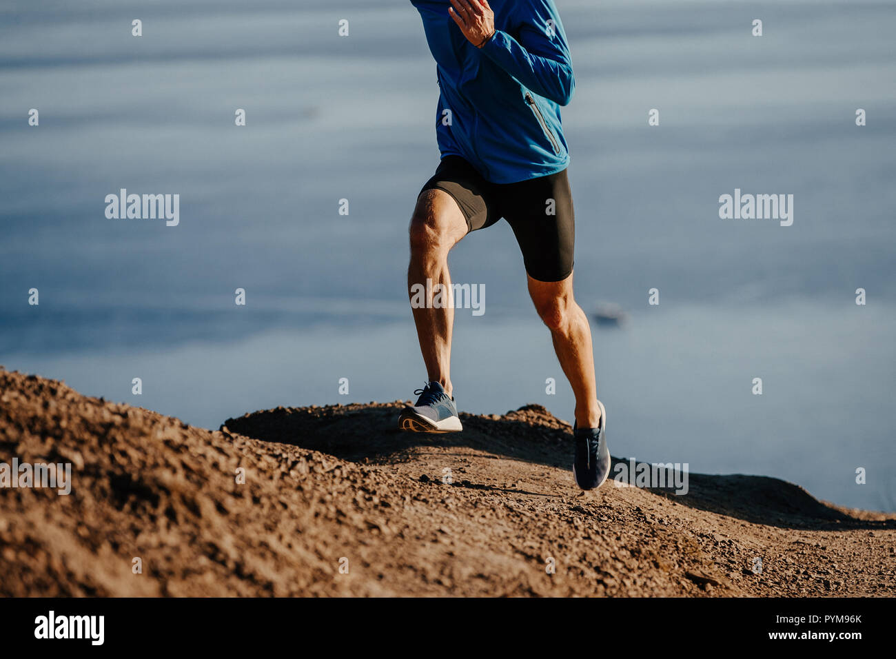 L'uomo runner run ripida montagna sullo sfondo del mare Foto Stock