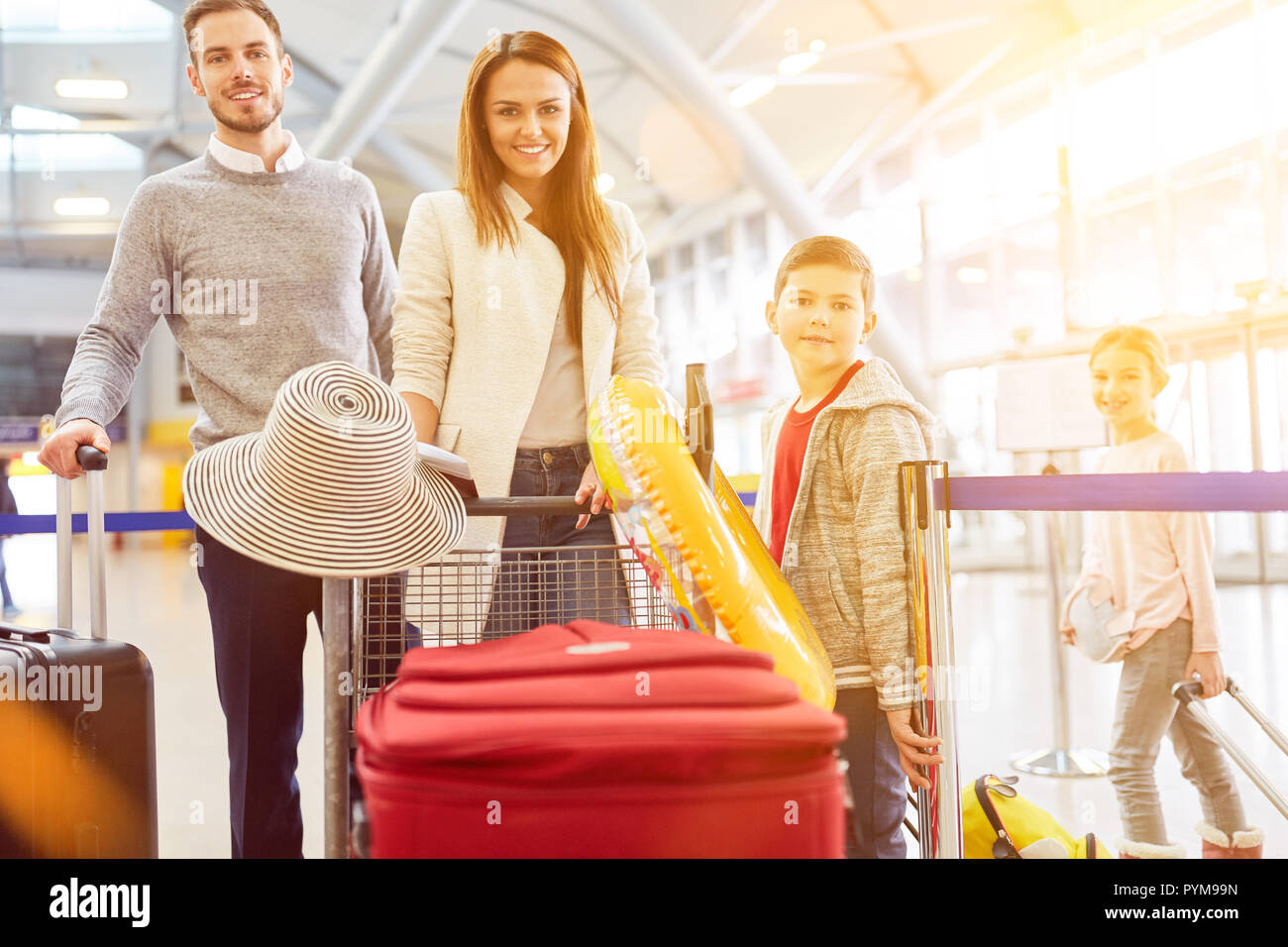 Famiglia con due bambini all'aeroporto di partenza per le vacanze estive Foto Stock