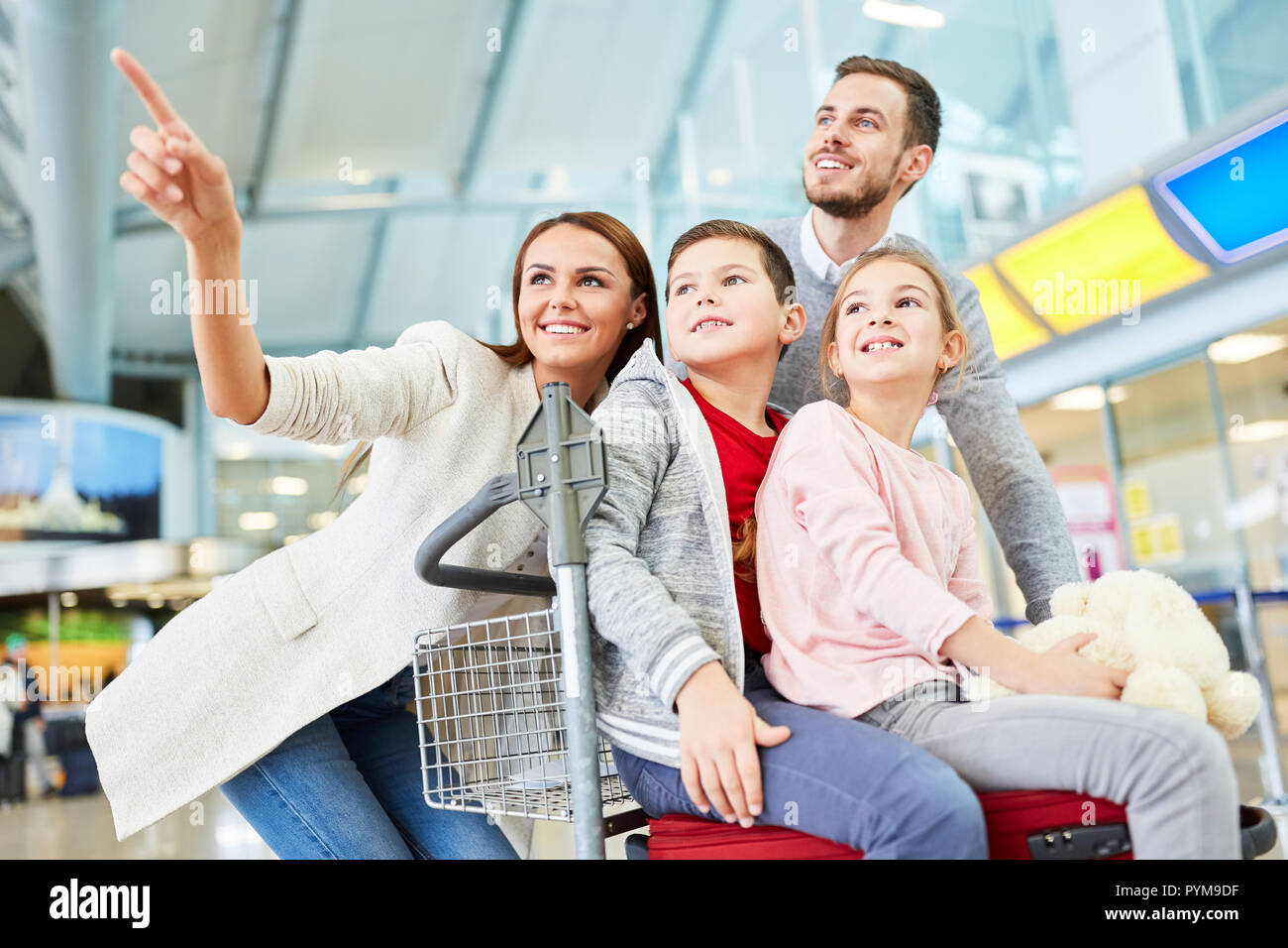 La famiglia felice e due bambini nel terminal dell'aeroporto sulla strada per una vacanza in famiglia Foto Stock