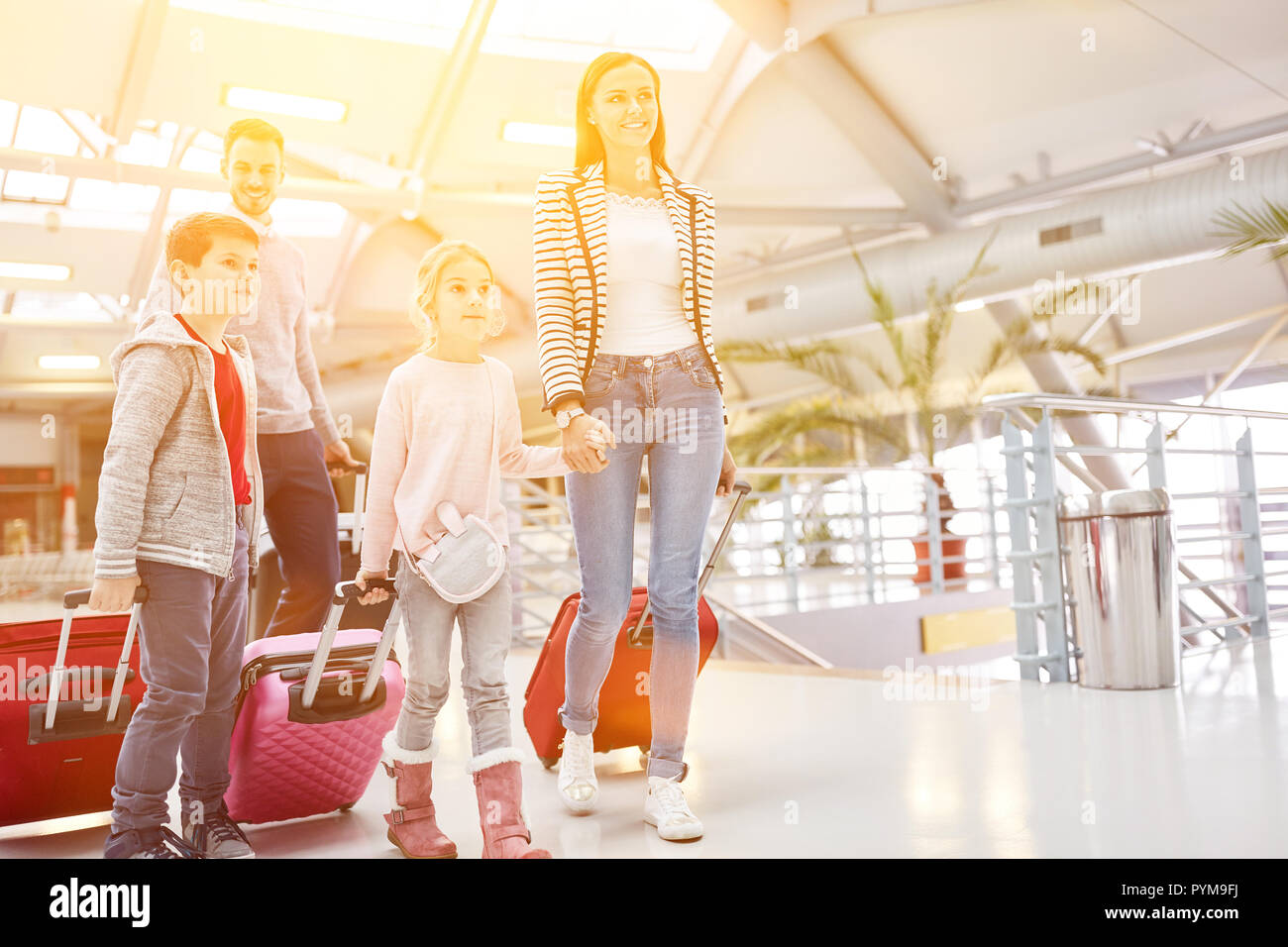 Famiglia in vacanza in aeroporto con i bambini e con i bagagli sul viaggio Foto Stock