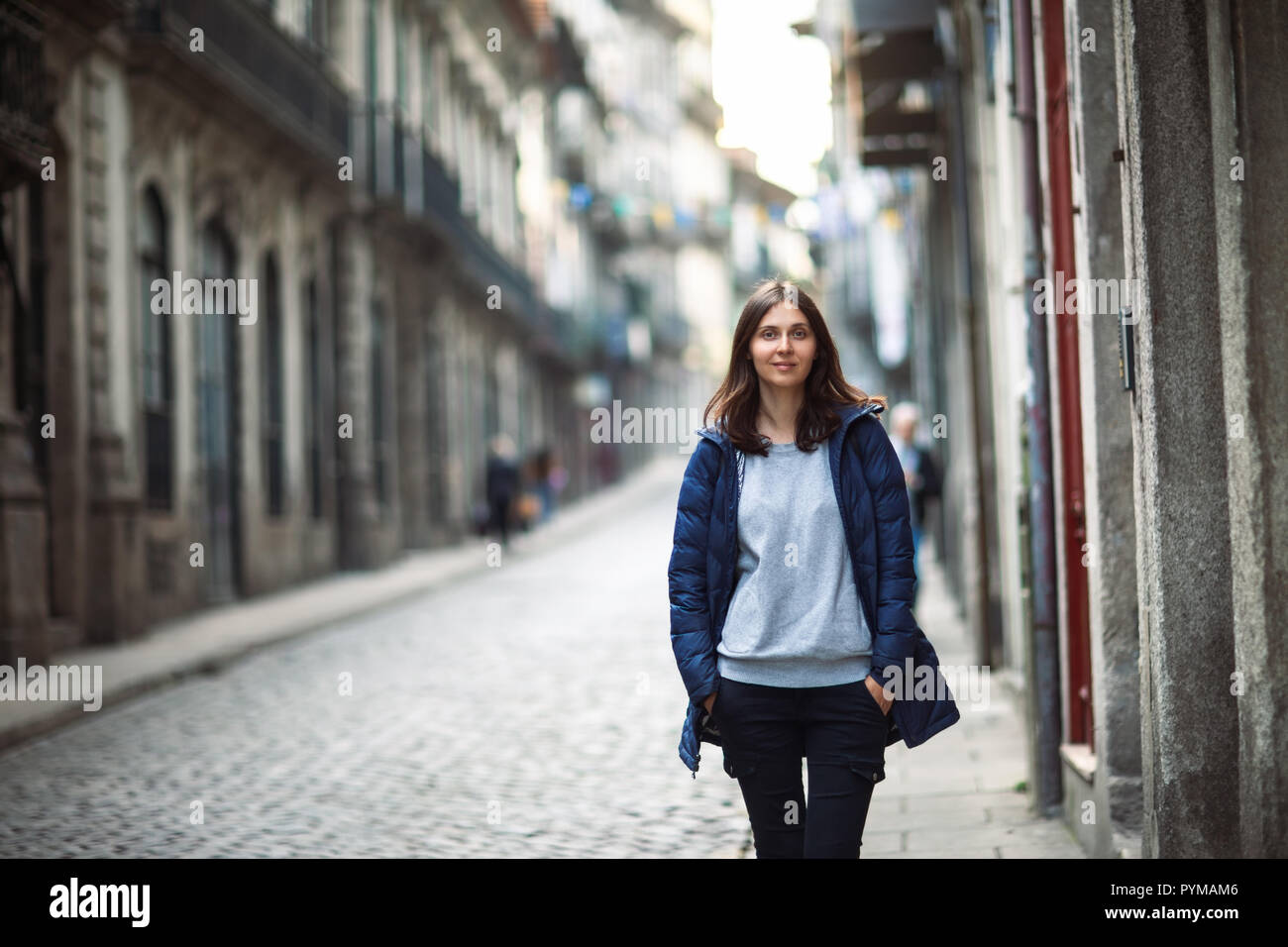 Giovane donna in posa sul vuoto via della città di Porto. Concetto di viaggio Foto Stock