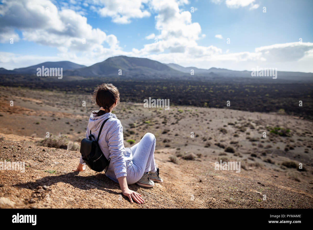 Viaggiatore donna relax in montagna in un unico paesaggio di Lanzarote, Parco Nazionale di Timanfaya Foto Stock