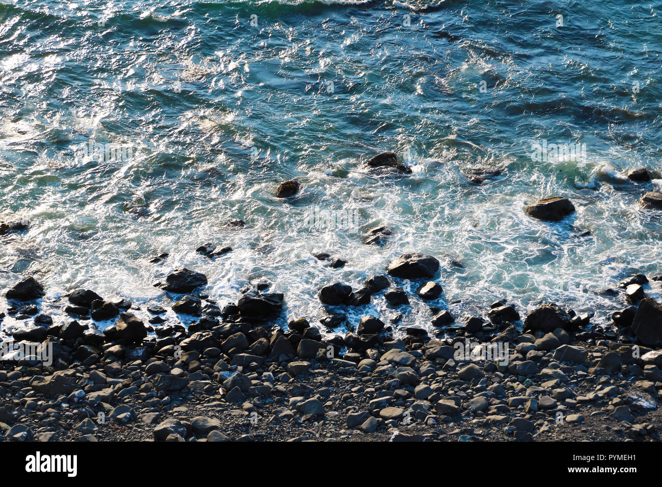 Oceano sullo sfondo del paesaggio, acqua con onde e rock, vista oceano dal di sopra, costa. Foto Stock