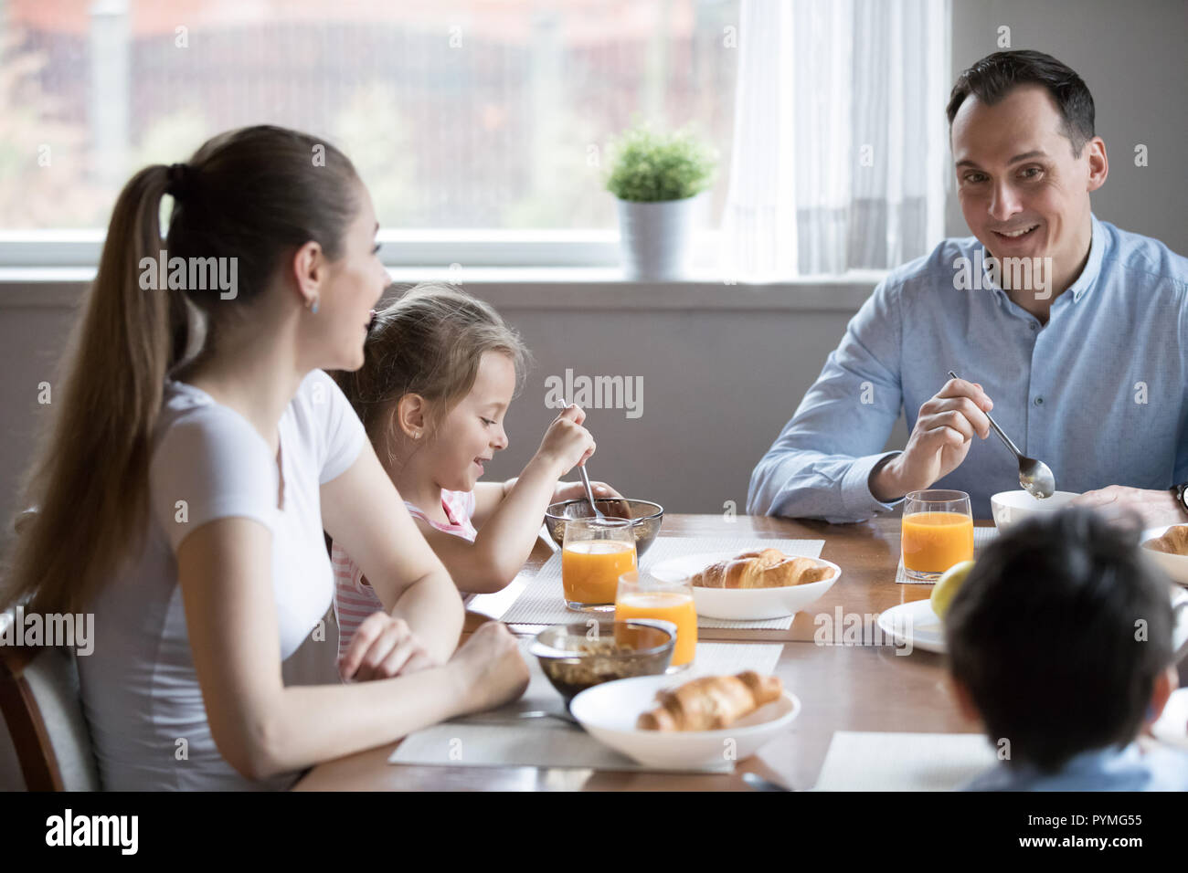 Felice famiglia attraente avente una sana prima colazione seduta nel Foto Stock