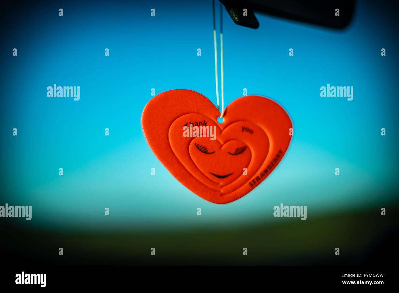Rosso a forma di cuore ad auto profumatore contro sfondo blu Foto Stock