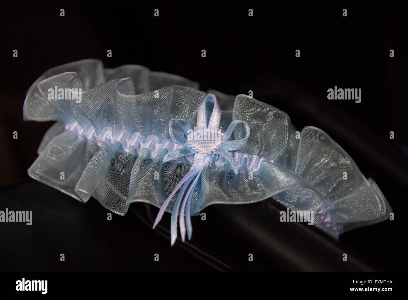La luce blu giarrettiera del merletto disposti sulla pelle scura Foto Stock