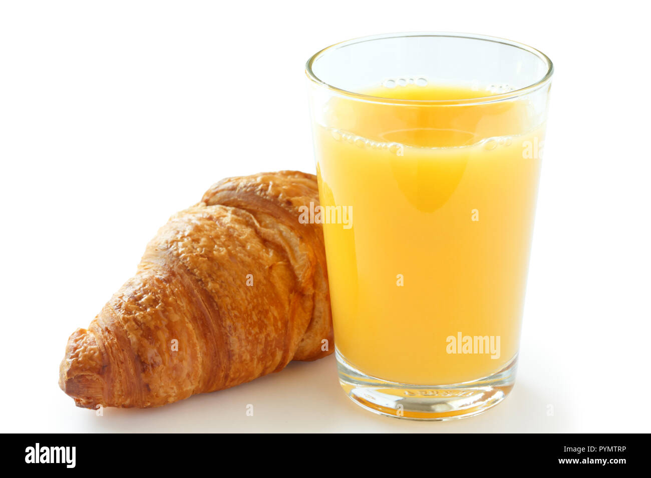 Singolo bicchiere di succo di arancia con un cornetto dietro. Foto Stock