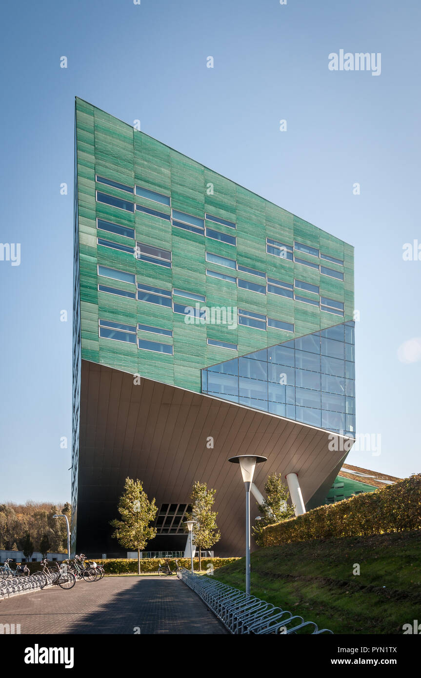 Verde moderno edificio per uffici con cavalletti di bici e moto. Foto Stock