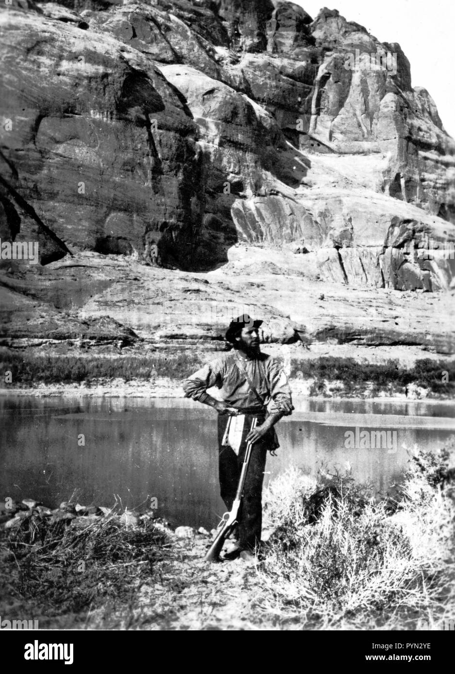 John F. Steward, membro dell'indagine Powell, in Glen Canyon del Fiume Colorado. Egli è mostrato con le attrezzature del campo tipiche di quelle prime indagini: pistola, pick, mappa case e una mensa. Questa foto è stata scattata in Kane County, Utah nel 1872. Foto Stock