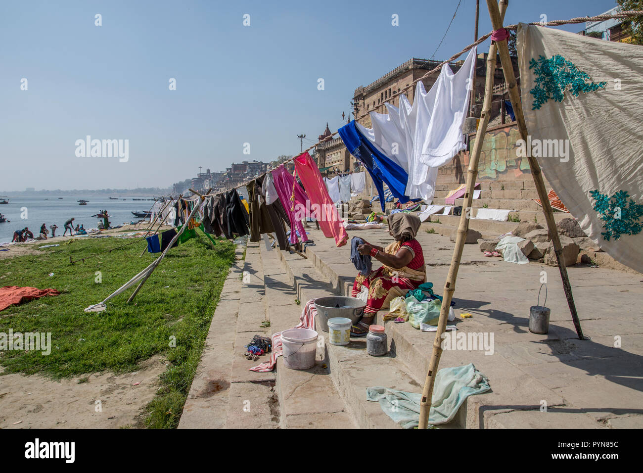 Servizio lavanderia giorno sul fiume Gange, Varanasi, Uttar Pradesh, India. Vestiti e biancheria sono lavati nel fiume e la diffusione a secco sulla sua riva Foto Stock