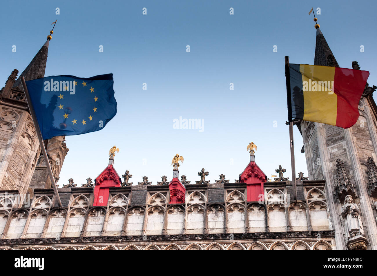 Una vista dettagliata della facciata del fiammingo corte provinciale (Provinciaal Hof) con golden angeli e europei e il Belgio bandiere. Bruges, Belgio UE Foto Stock