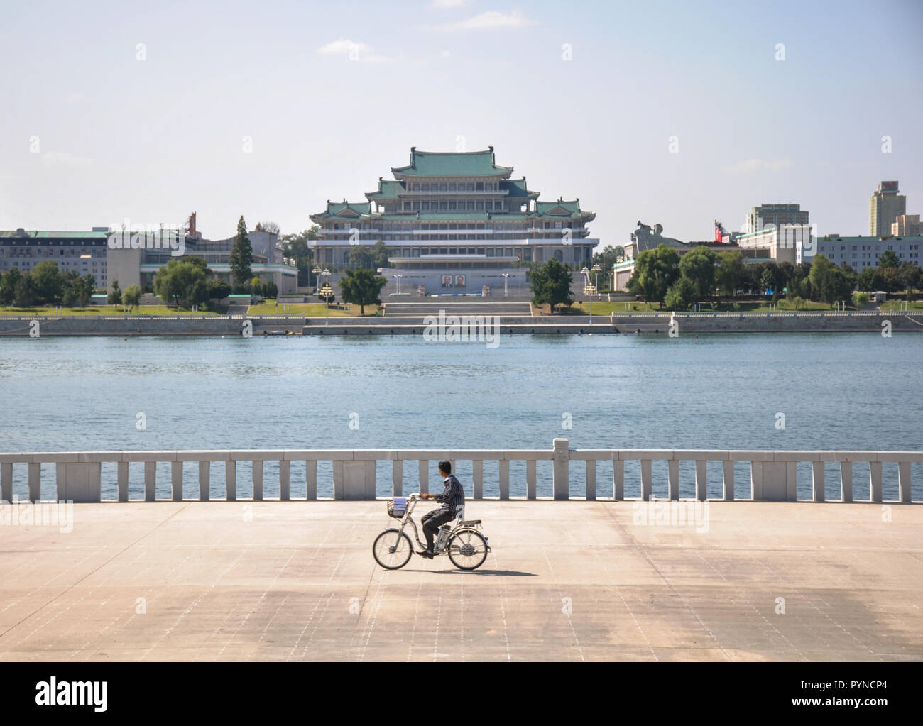 09/09/2018: un ciclista solitario è passando da Kim il Sung square e il suo palazzo su una bicicletta. Foto Stock