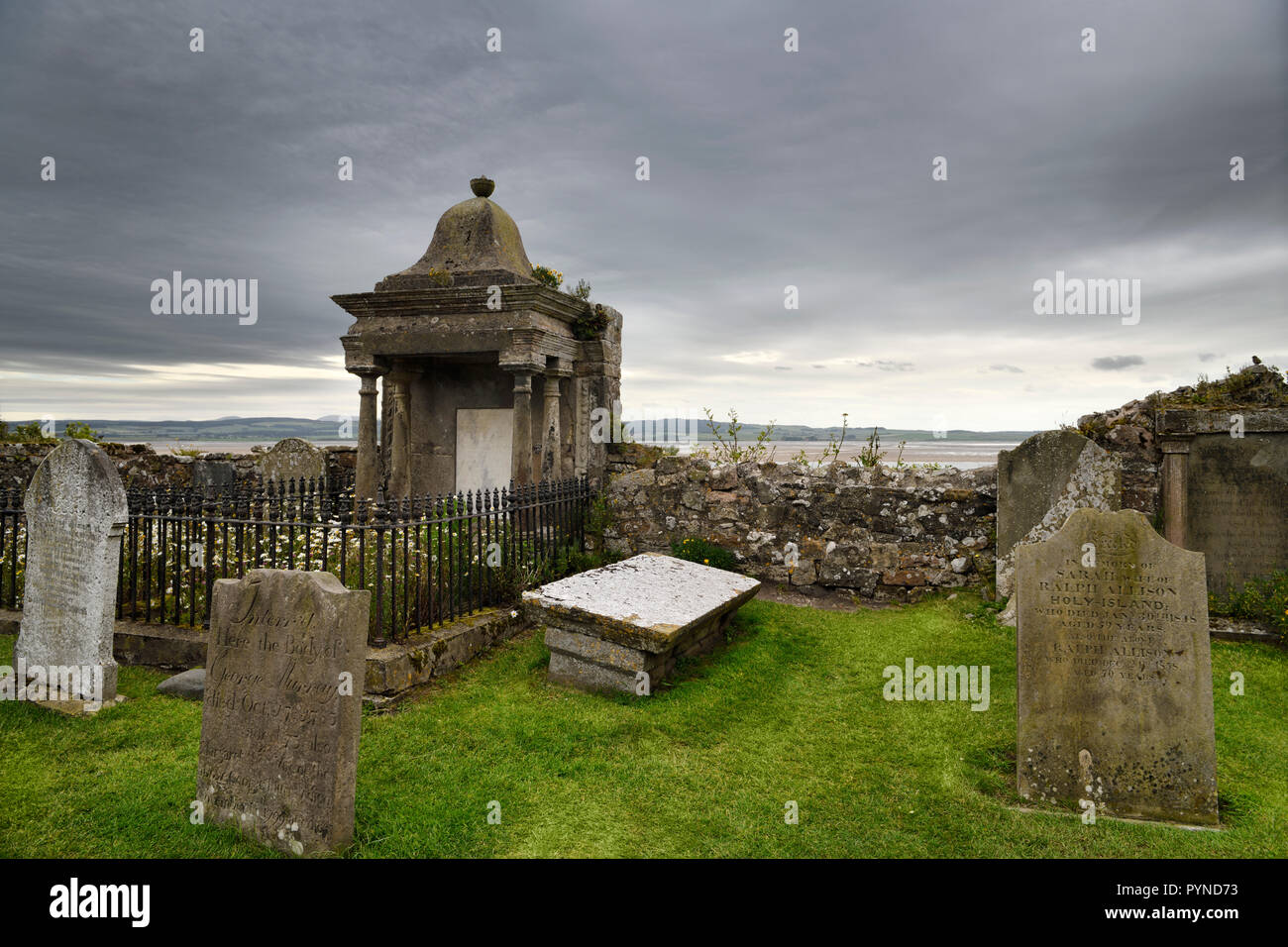 Le nuvole nel cimitero presso la chiesa parrocchiale di Santa Maria Vergine sull isola di marea di Isola Santa di Lindisfarne England Regno Unito Foto Stock
