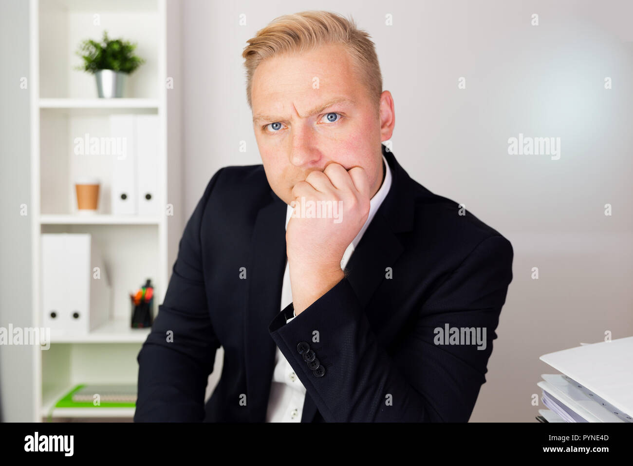 Imprenditore cercando seriamente ad un blu scuro tuta e pensare. La leadership aziendale concetto. Foto Stock