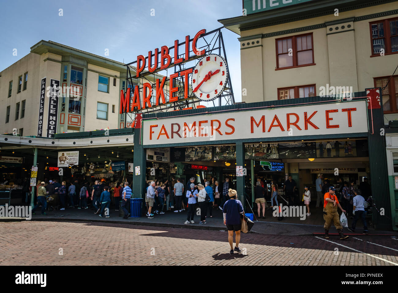Mercato degli Agricoltori, del Mercato di Pike Place entrata con la folla in una giornata di sole, del centro cittadino di Seattle, nello stato di Washington, USA. Foto Stock