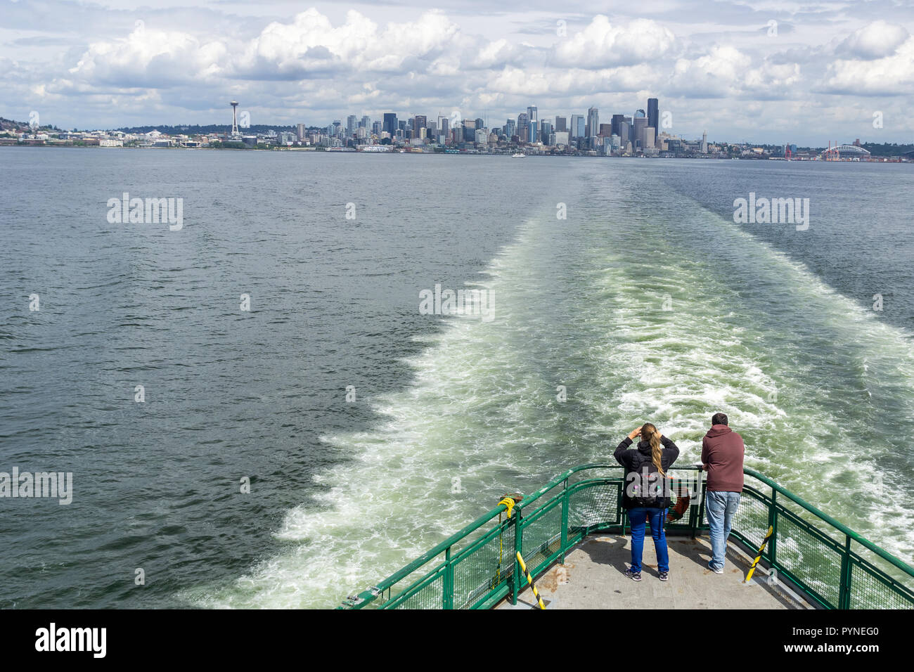 Due passeggeri guardando la skyline di Seattle dal traghetto in direzione di Bainbridge Island, della Baia di Elliott, nello stato di Washington, USA. Foto Stock