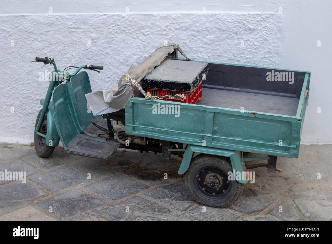 Un piccolo motociclo atto a trasportare merci attraverso le strette strade di Lindos,Rhodes, Grecia.Lindos è un piccolo popolare villaggio di pesca Foto Stock