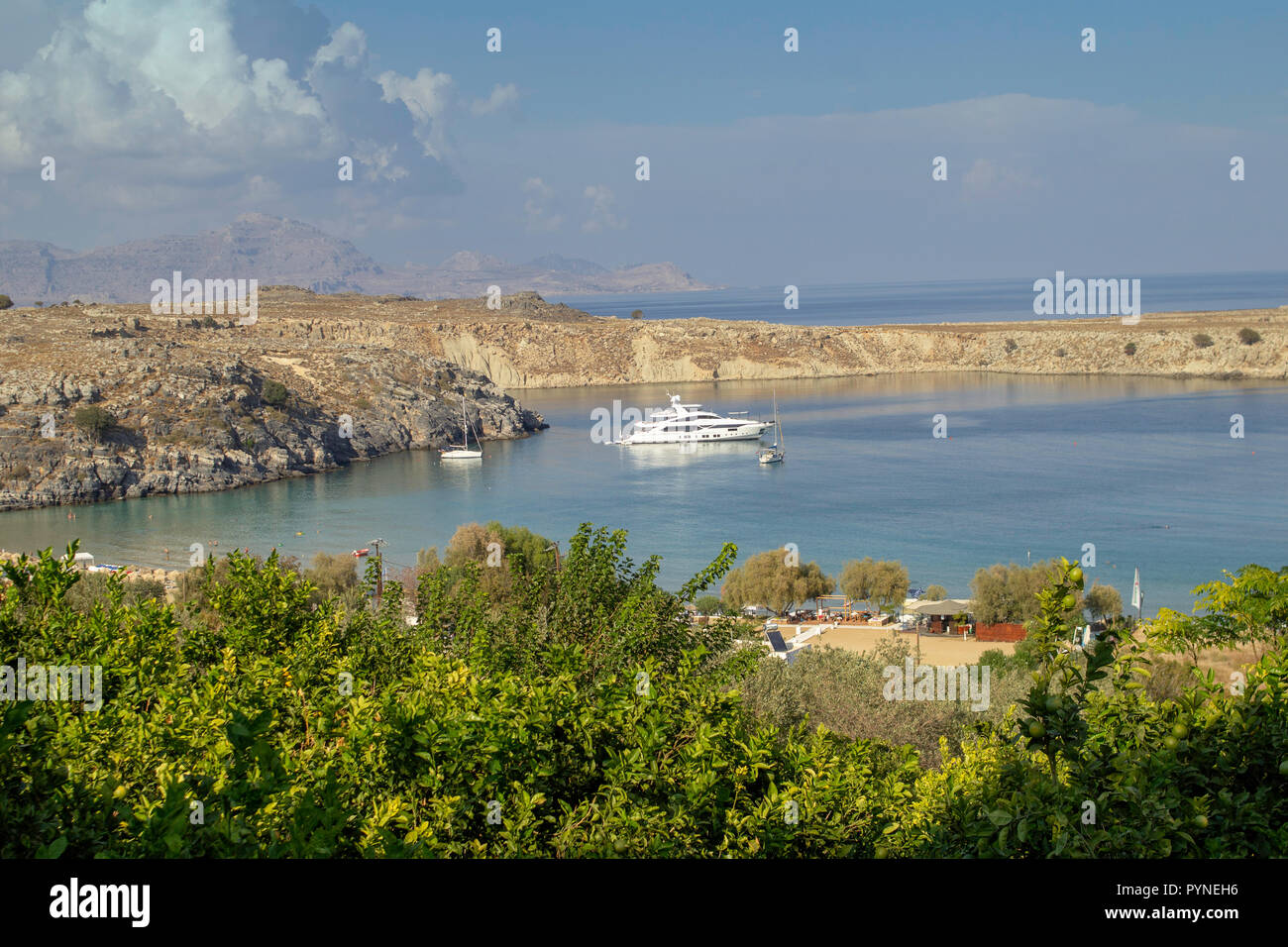 La baia di fronte al villaggio di Lindos a Rodi, Grecia, una popolare località turistica le spiagge offrono numerose opportunità per prendere il sole. Foto Stock