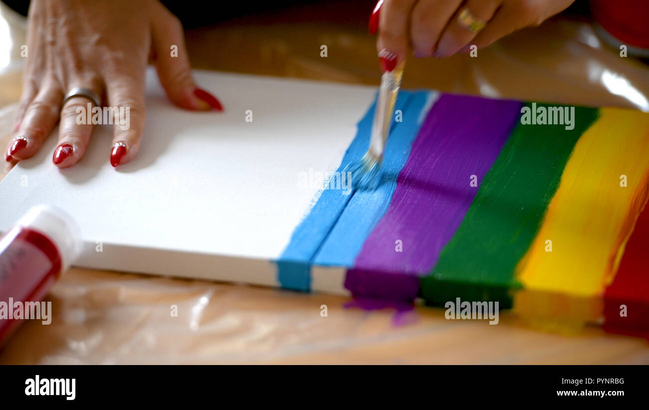 Artista femminile dipinto un arcobaleno con colori acrilici su tela, hoe  arte, DIY tutorial, colorato Foto stock - Alamy