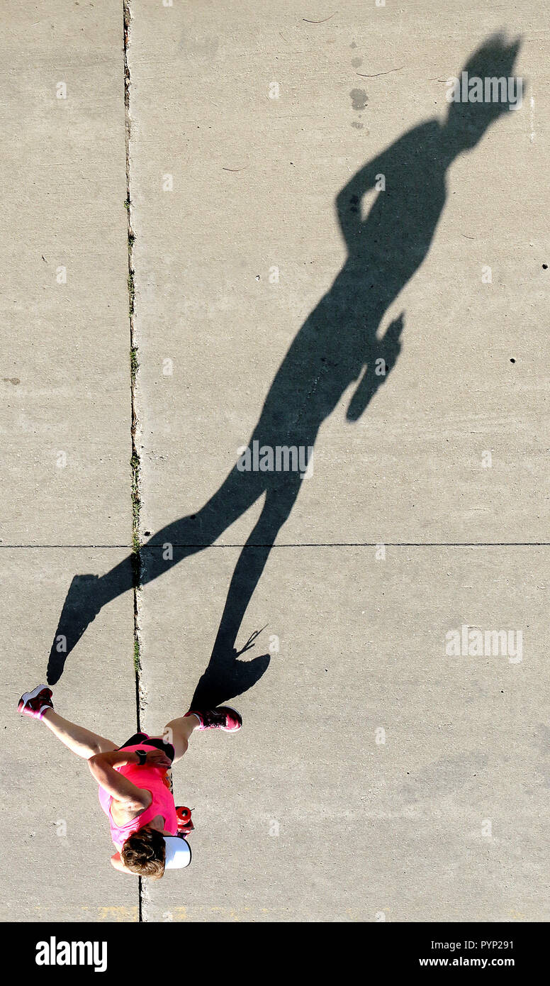 Davenport, Iowa, USA. 24Sep, 2017. Un viandante getta una lunga ombra nelle prime ore del mattino di domenica di luce, Sett. 24, 2017, vicino al moderno parco Woodmen durante il ventesimo in esecuzione della Maratona Quad-Cities. Macchina fotografica: Canon EOS 7D Mark II; Lente: EF70-200mm f/2.8L USM a 70mm; Esposizione: 1/1328 sec, f/6.3; ISO 400 manuale; misurazione valutativa. Credito: John Schultz/Quad-City volte/ZUMA filo/Alamy Live News Foto Stock