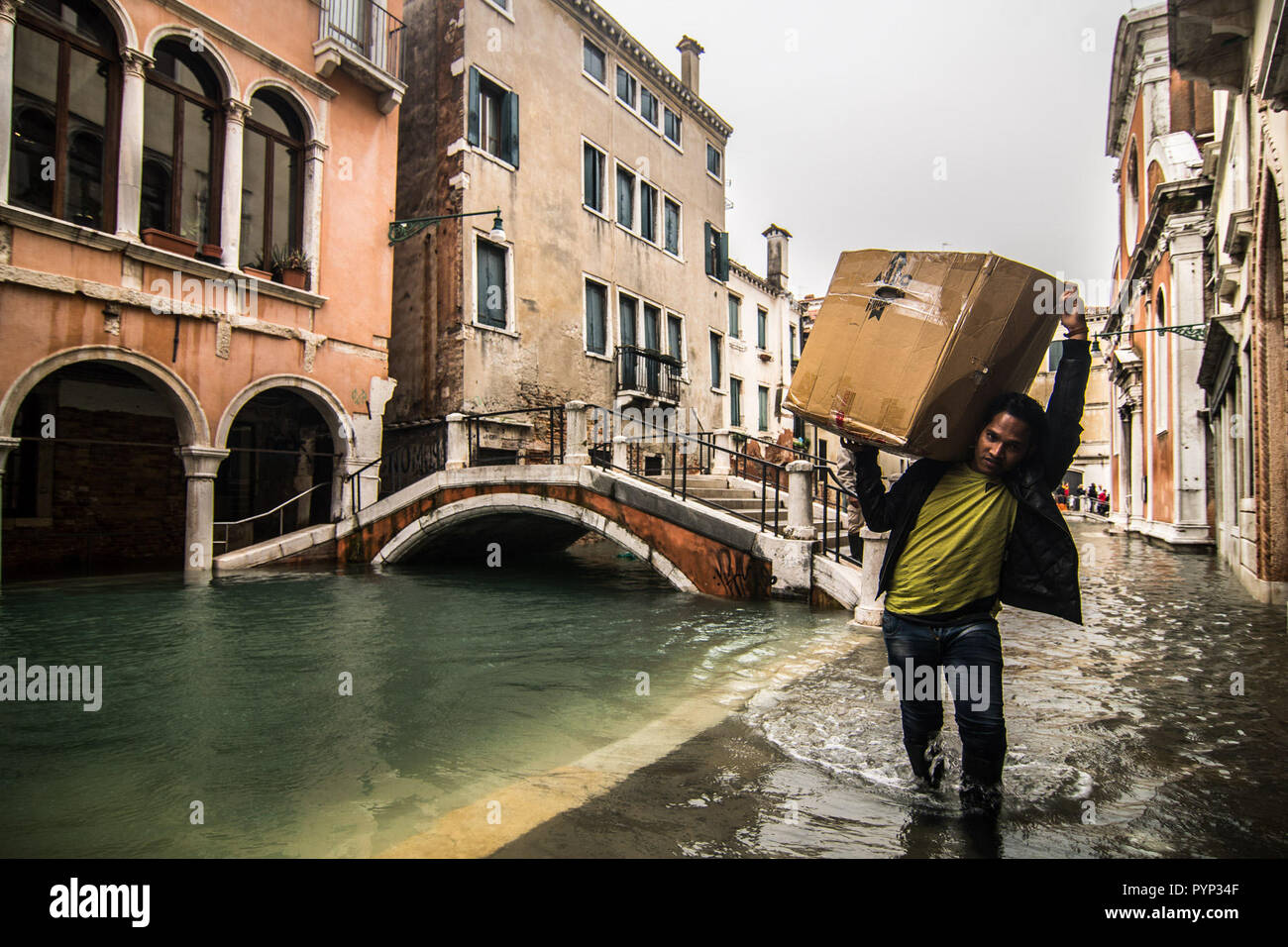 Venezia, Italia. 29 ottobre, 2018. Gli uomini a piedi lungo un canale durante l'alta marea su ottobre 29, 2018 a Venezia, Italia. A causa dell'eccezionale livello di "acqua alta" o "Alta Marea' che ha raggiunto 156 cm oggi veneziano, gli ospedali e le scuole sono state chiuse dalle autorità e cittadini hanno consigliato di lasciare le loro case. Questo livello di alta marea è stato raggiunto nel 1979. © Simone Padovani / risveglio / Alamy Live News Foto Stock