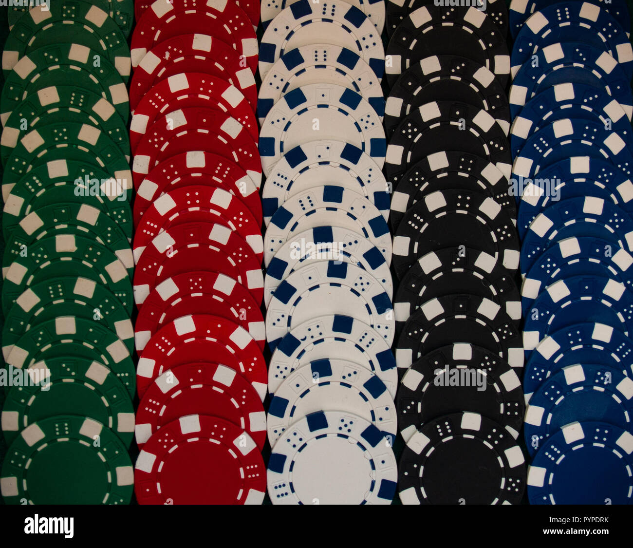 Poker chips di diversi colori su un tappeto verde Foto Stock