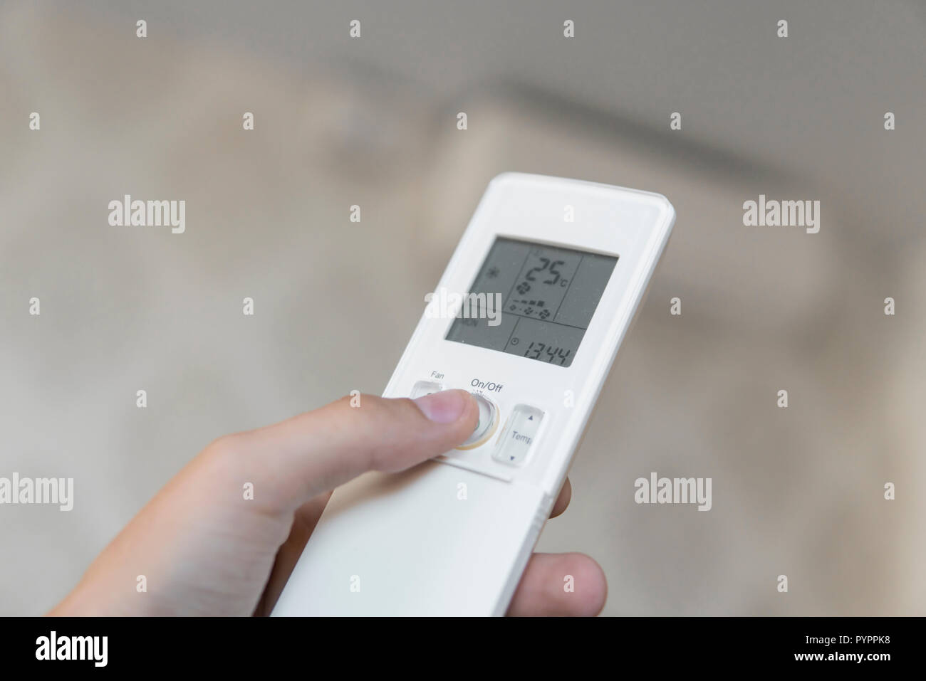 Mano con telecomando diretto sul condizionatore a parete. Mano d'uomo  utilizzando il telecomando apri il condizionatore d'aria è raffreddata a 25  gradi Celsius nella sua camera da letto Foto stock - Alamy