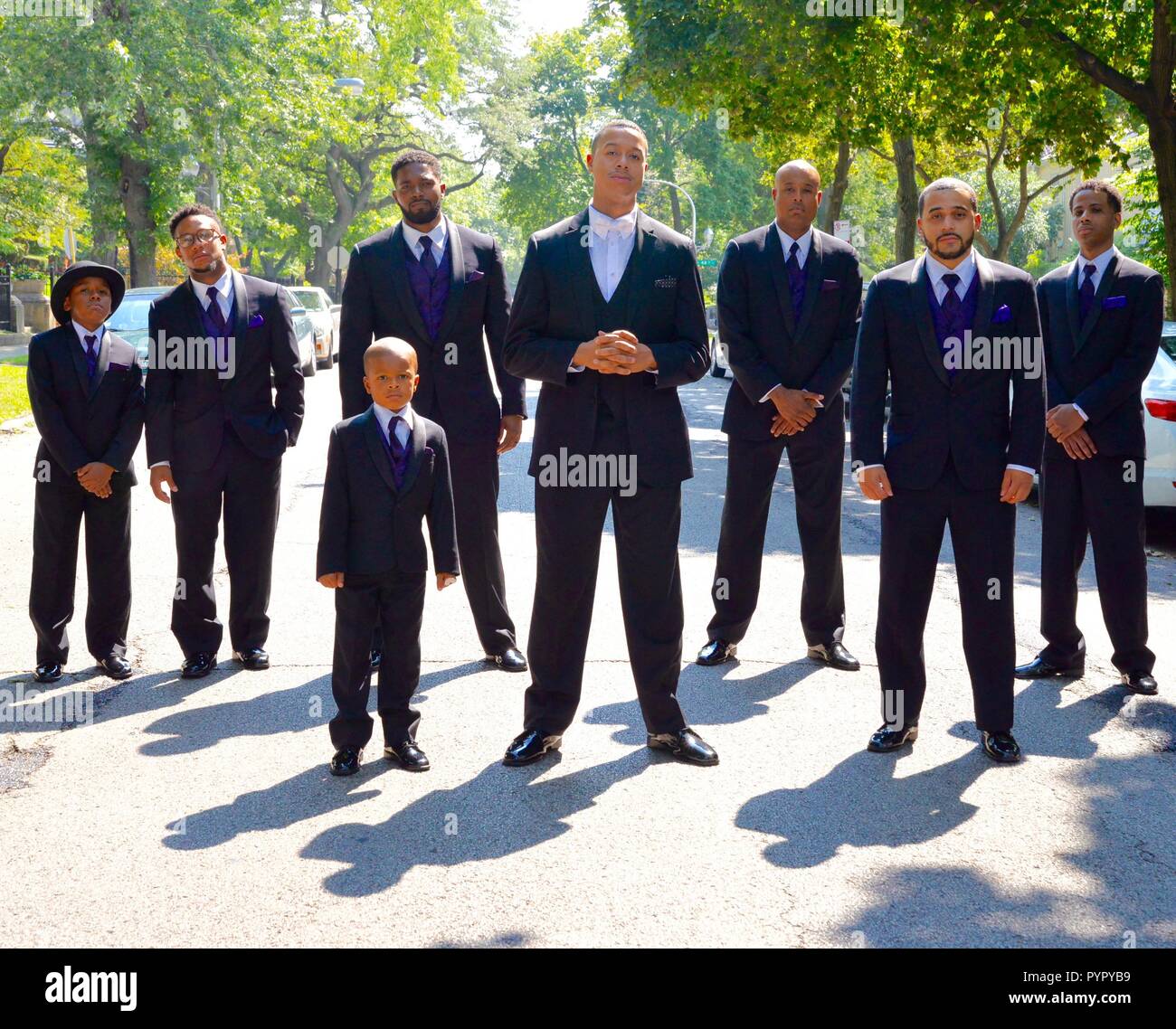 Un gruppo di uomini neri in giacca con 2 bambini Foto Stock