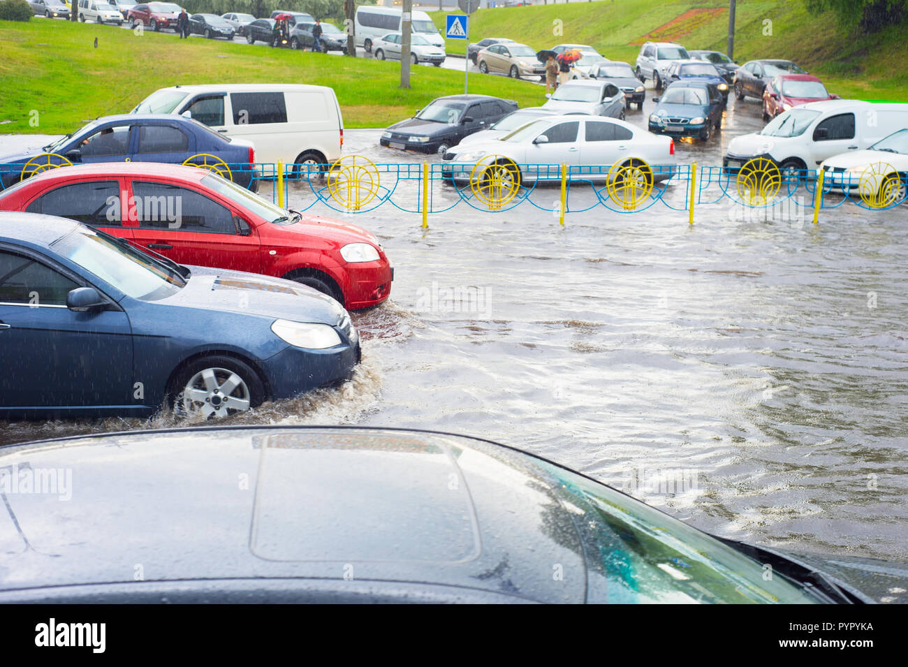 Scena cittadina con il traffico di auto sulla strada allagata, Kiev, Ucraina Foto Stock