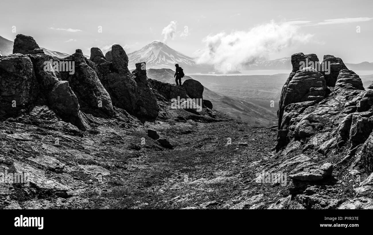 Petropavlovsk-Kamchatsky regione, la Russia - Luglio 10, 2018: bianco e nero silhouette del turista sul picco di una montagna. Foto Stock