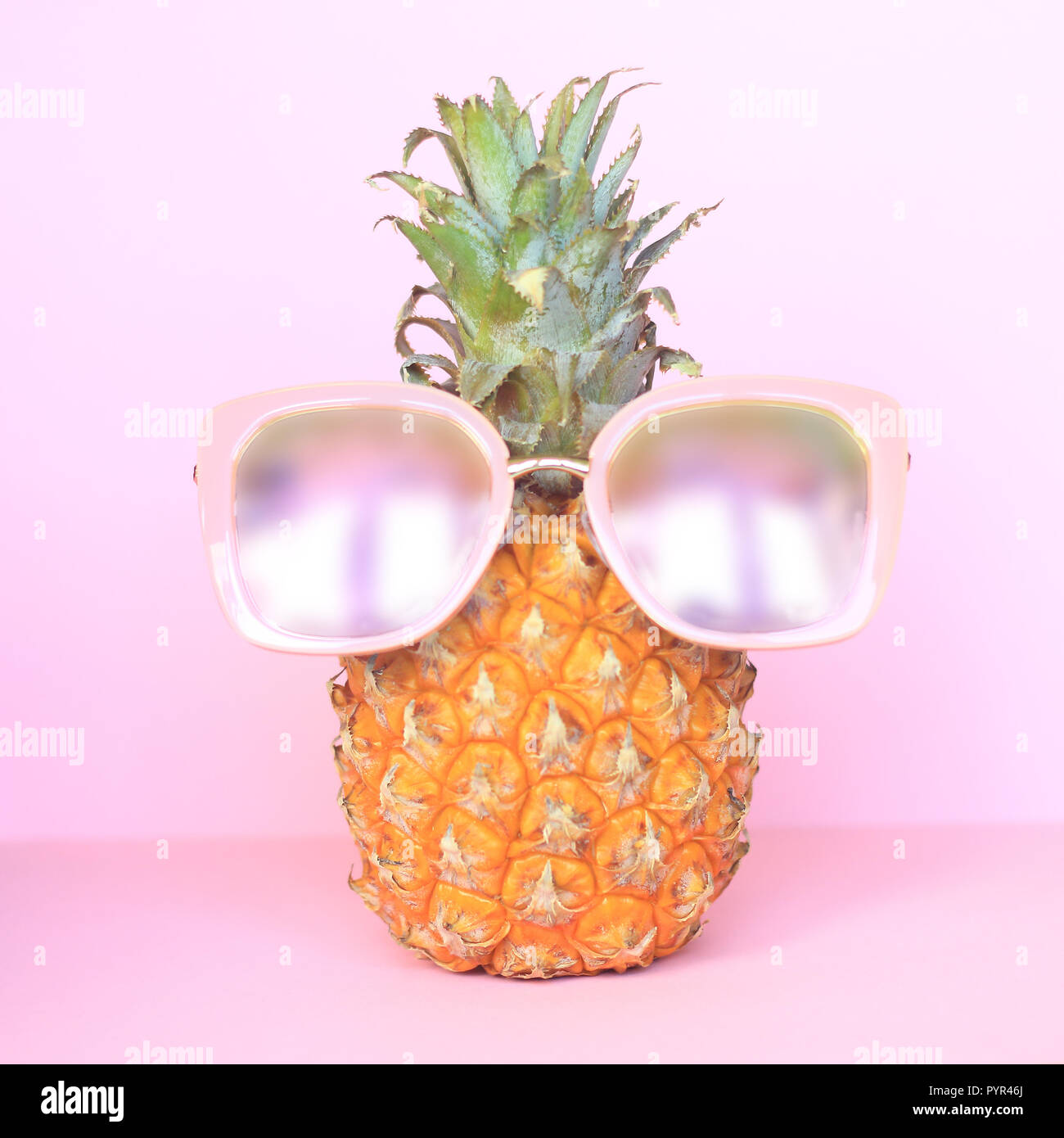 Succosa ananas in occhiali da sole su sfondo rosa.foto con spazio di copia Foto Stock
