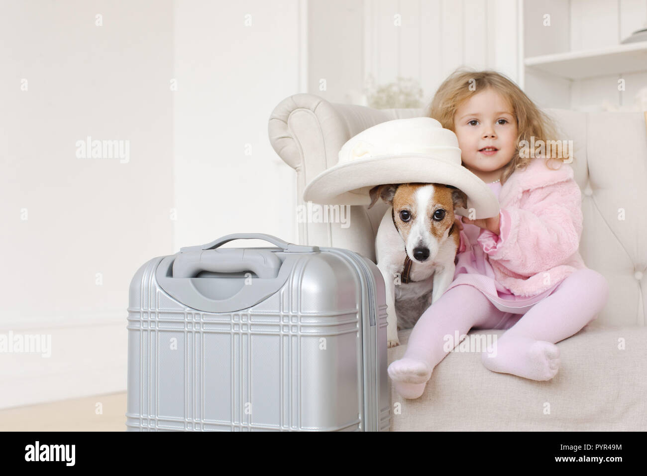 Ragazza e dog sitter vicino a valigia Foto Stock