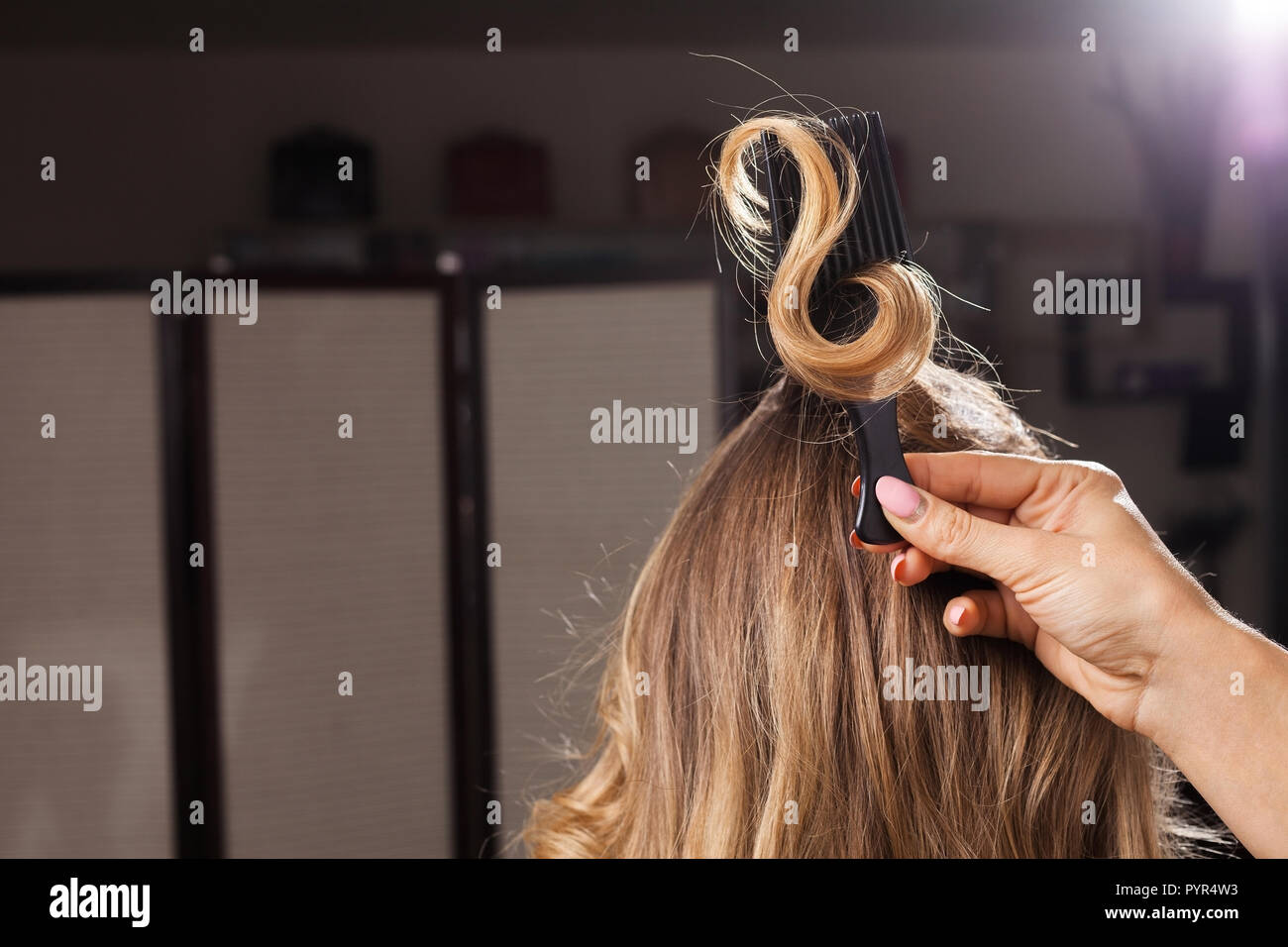 Parrucchiere tenendo un arricciamento dei capelli con un pettine Foto Stock