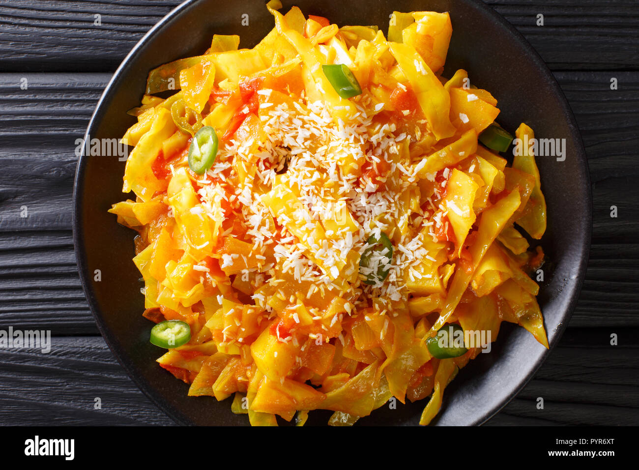 Cavolo Bhaji Goan Spiced Stir Fry con noce di cocco close-up su una piastra sul tavolo. Parte superiore orizzontale vista da sopra Foto Stock