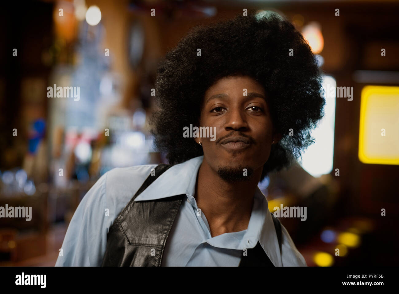 Ritratto di un fiducioso giovane con una parentesi afro nella città di notte. Foto Stock