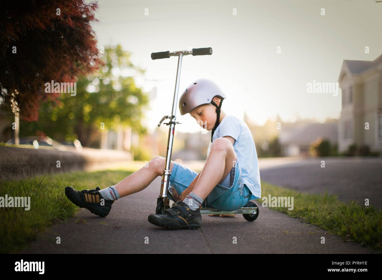 Ragazzo giocando con un push scooter al di fuori. Foto Stock