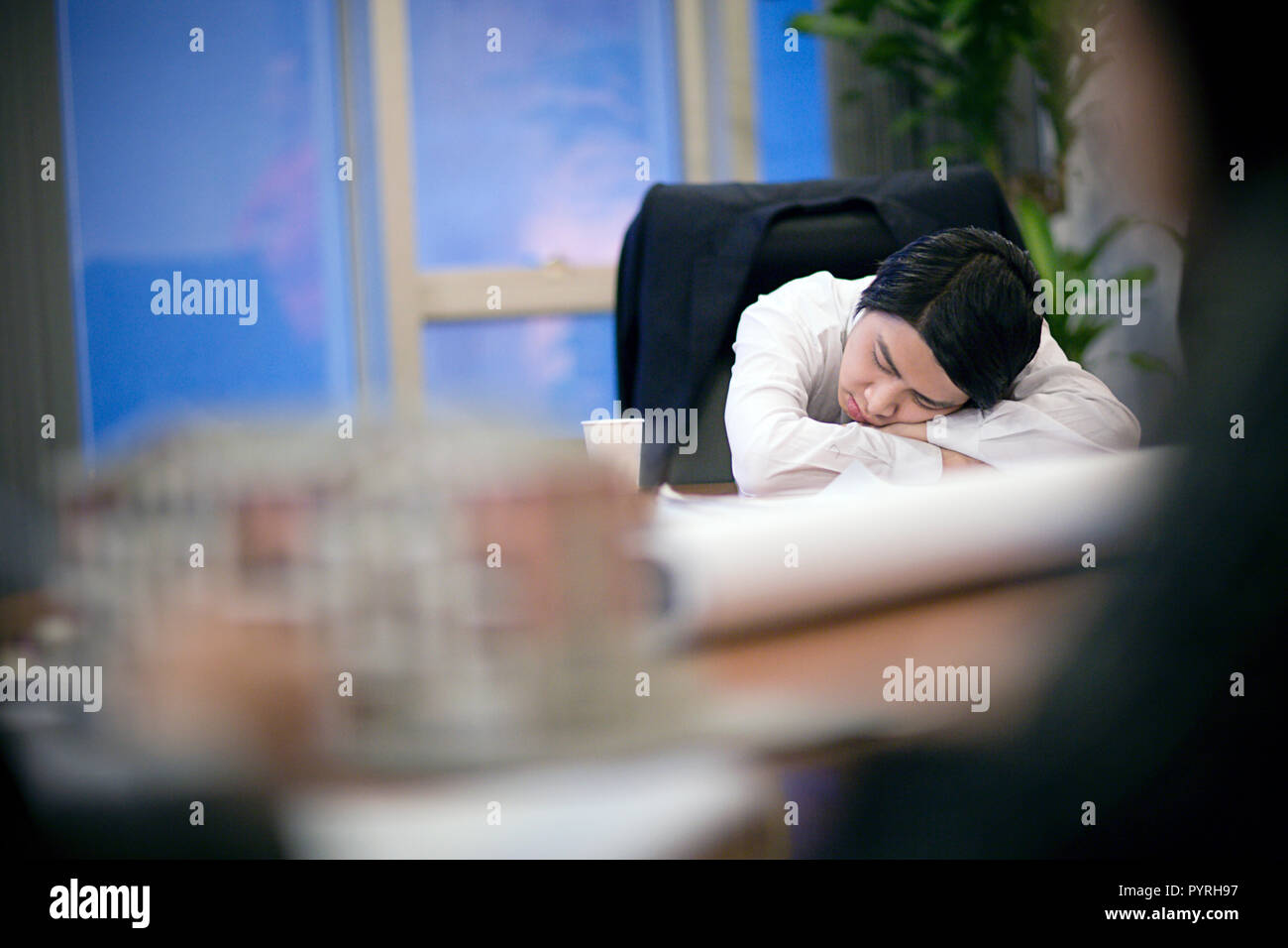 Giovane imprenditore addormentato alla sua scrivania. Foto Stock