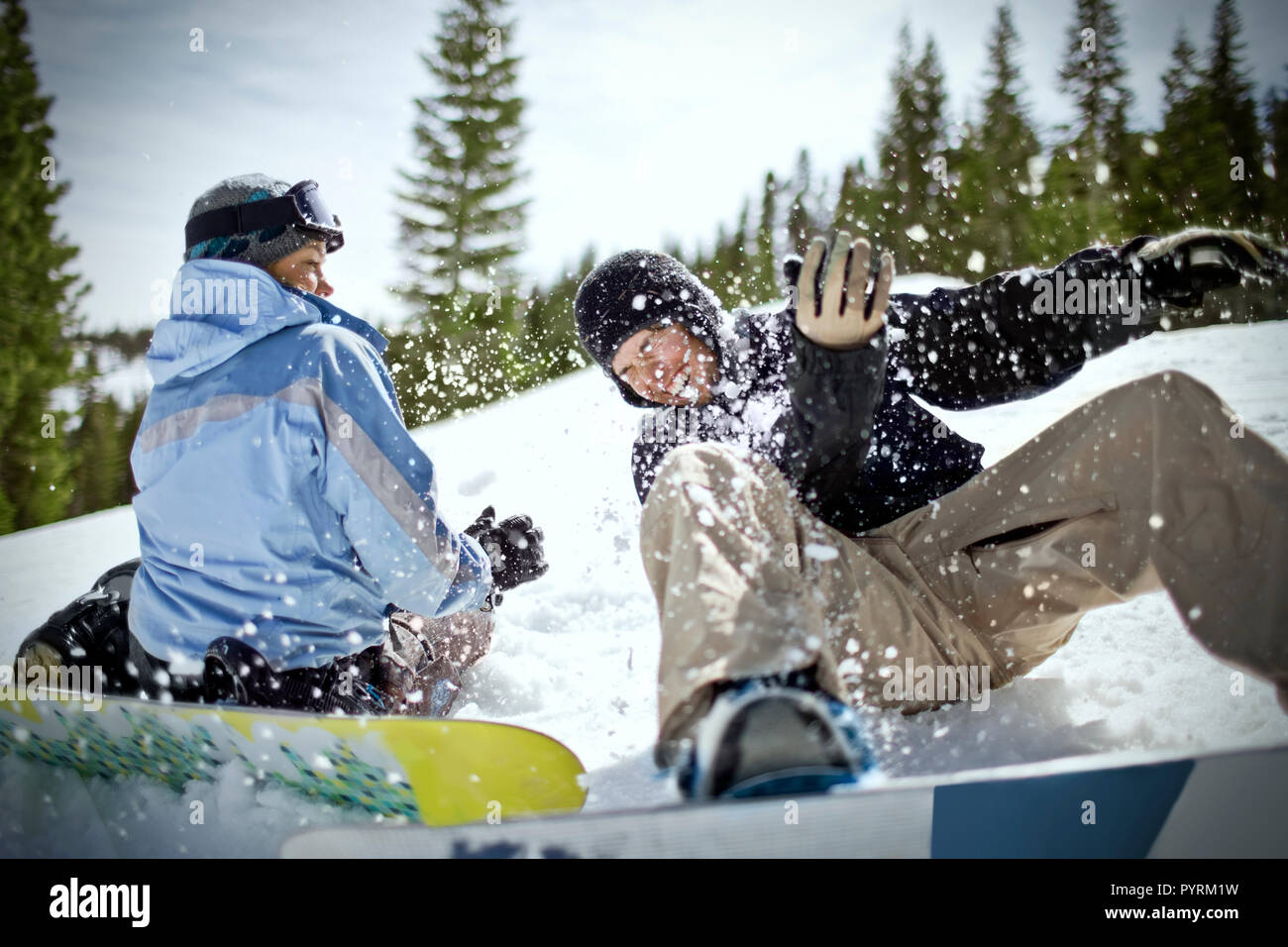 Coppia felice avendo divertimento con le loro tavole da snowboard all'aperto nella neve. Foto Stock