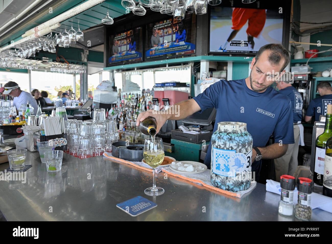 Barista maschio versando un bicchiere di vino bianco a Bud e alley's Bar e Grill ristorante sul tetto in Seaside Florida, Stati Uniti d'America. Foto Stock